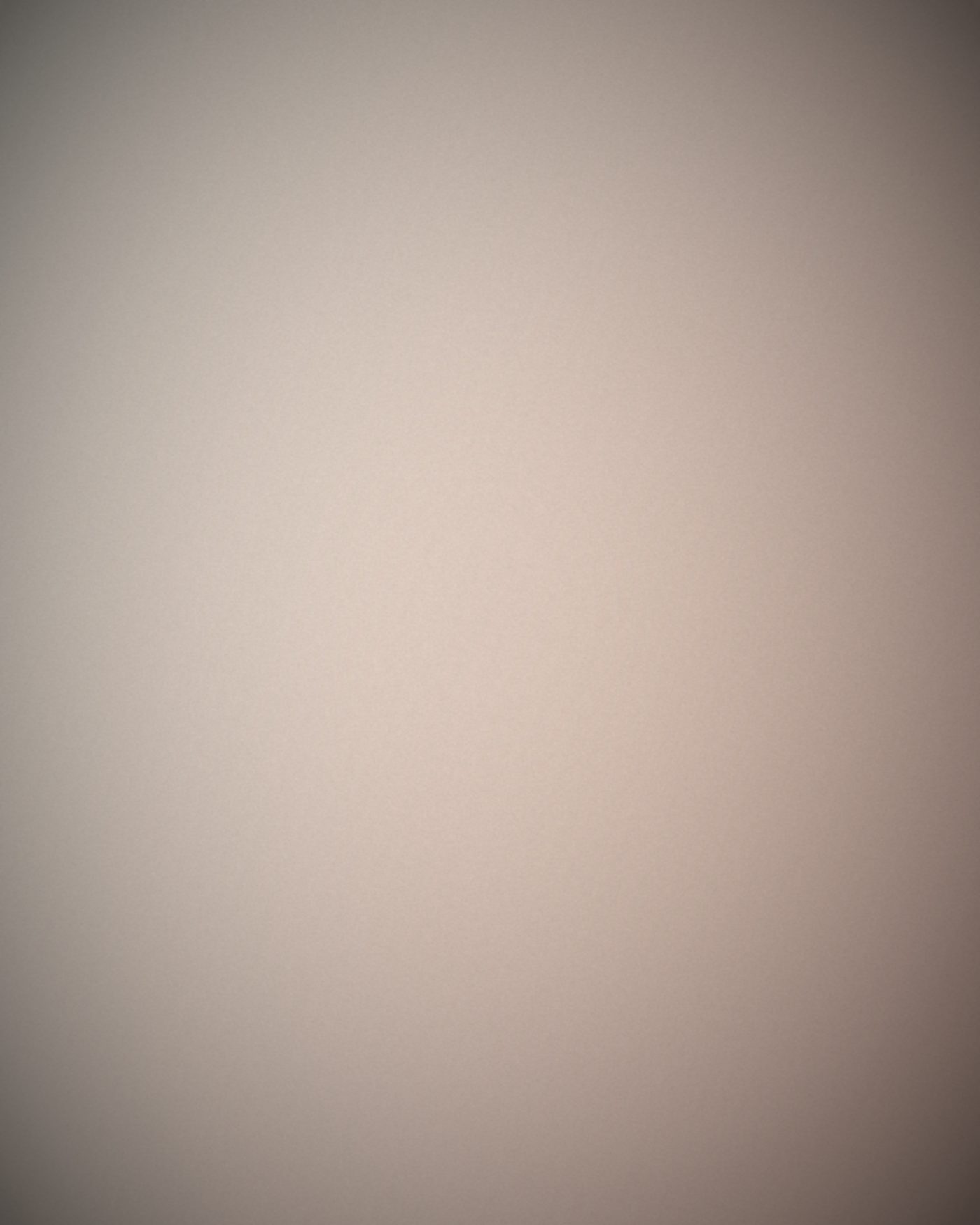 Quiet plaster bedroom corner in soft afternoon light.