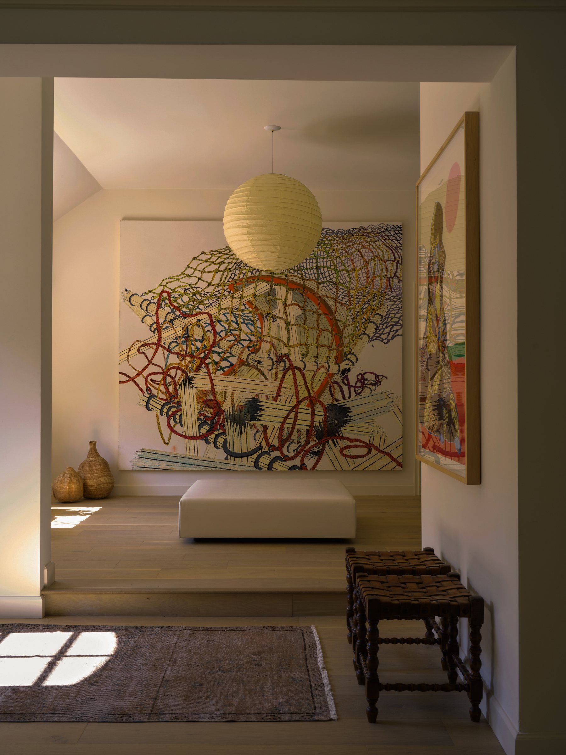 Entry hallway with a large colorful abstract painting and a woven paper pendant light.