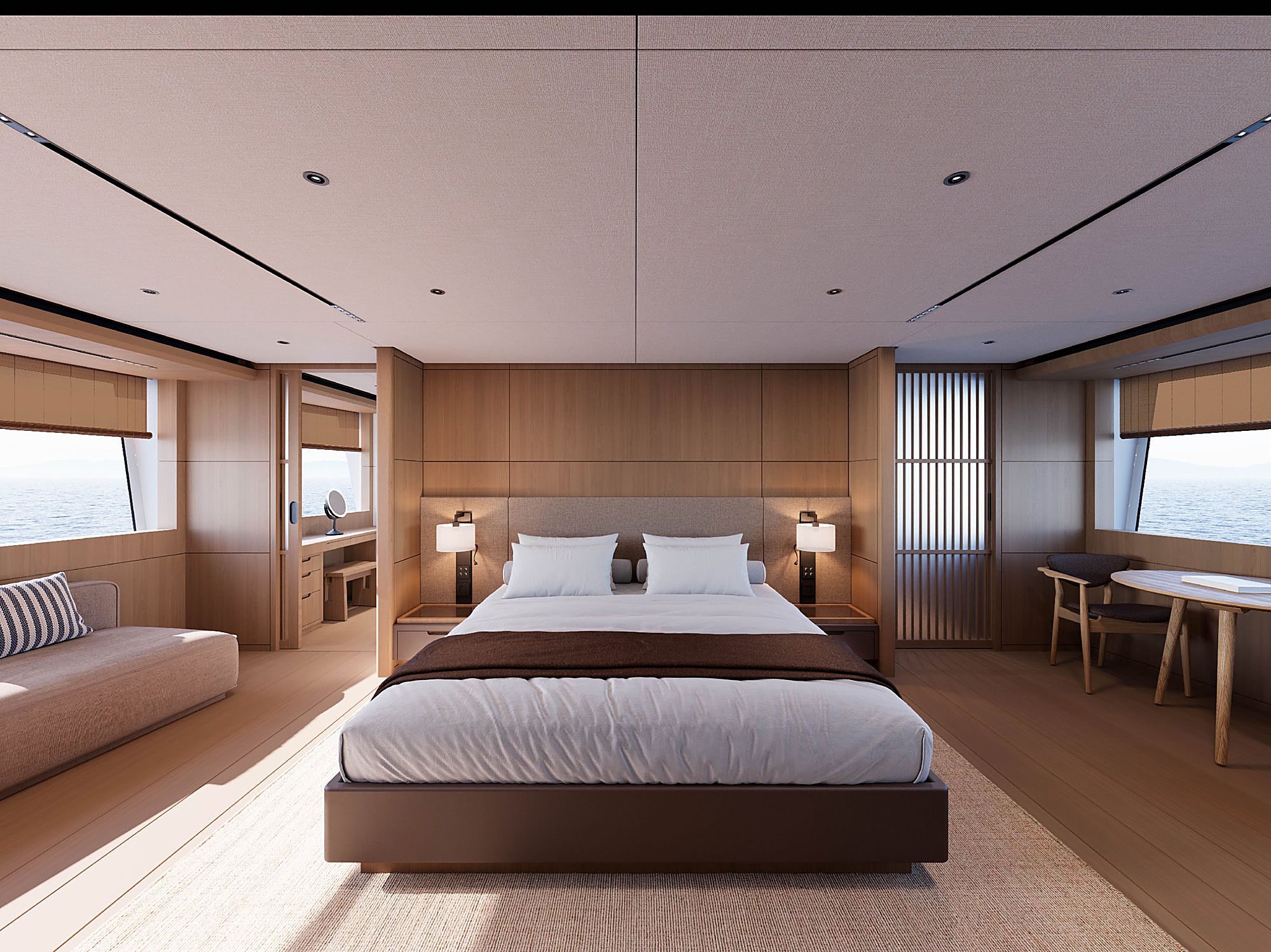 Primary stateroom with a dark platform bed, a striped throw pillow, and round portholes along the hull.