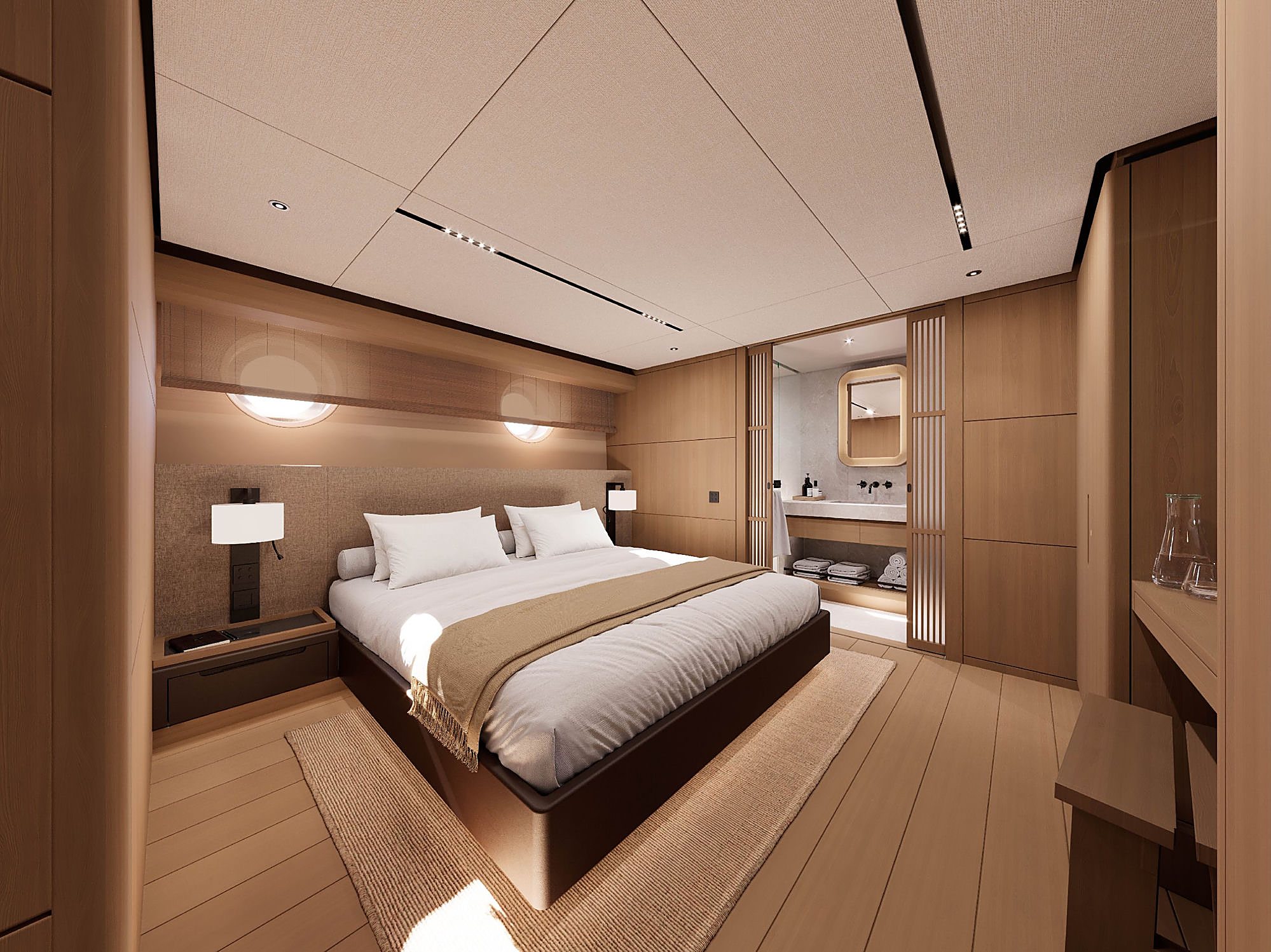 Guest stateroom with a dark platform bed, a sliding door to the ensuite, and a desk beneath round portholes.