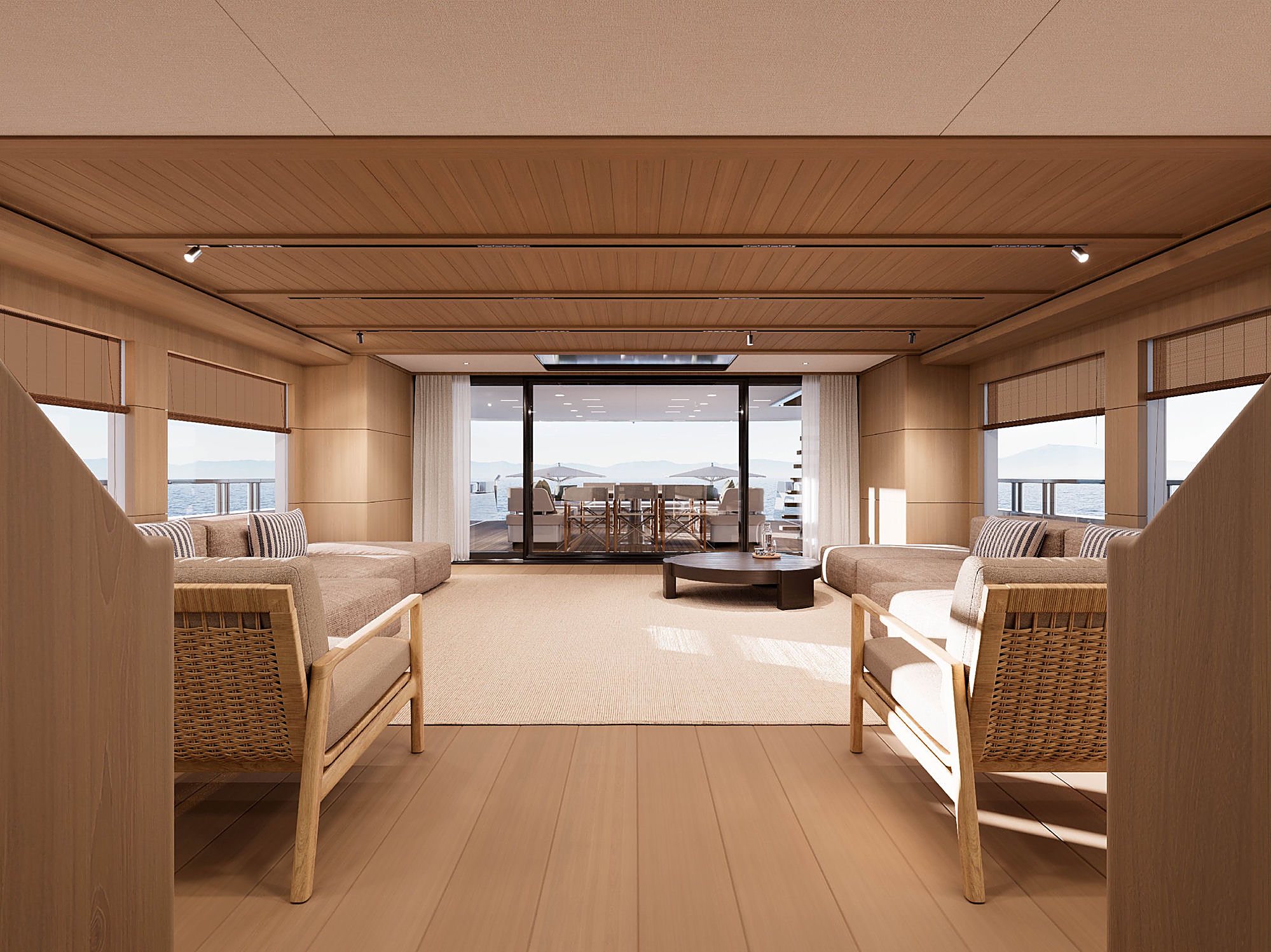 Interior lounge opening onto the covered aft deck, with rattan chairs in the foreground.